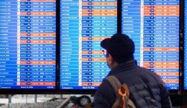 A man checks an arrivals board at Ronald Reagan National Airport in Arlington, Virginia, that shows several cancelled flights. Pic: AP