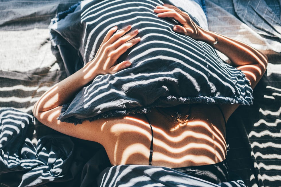 person relaxing under a striped pillow on a textured surface