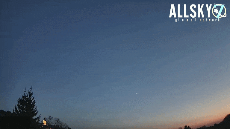 Looped video footage of a fireball meteor streaking through the evening sky