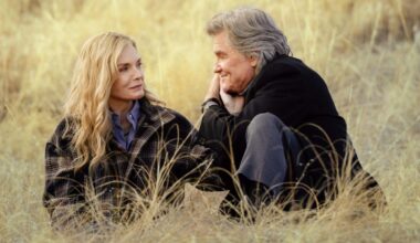 A production still from The Madison showing Michelle Pfeiffer and Kurt Russell sitting lovingly in a field.