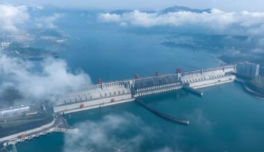 Aerial view of China’s Three Gorges Dam surrounded by water and low clouds, illustrating the massive hydropower project.