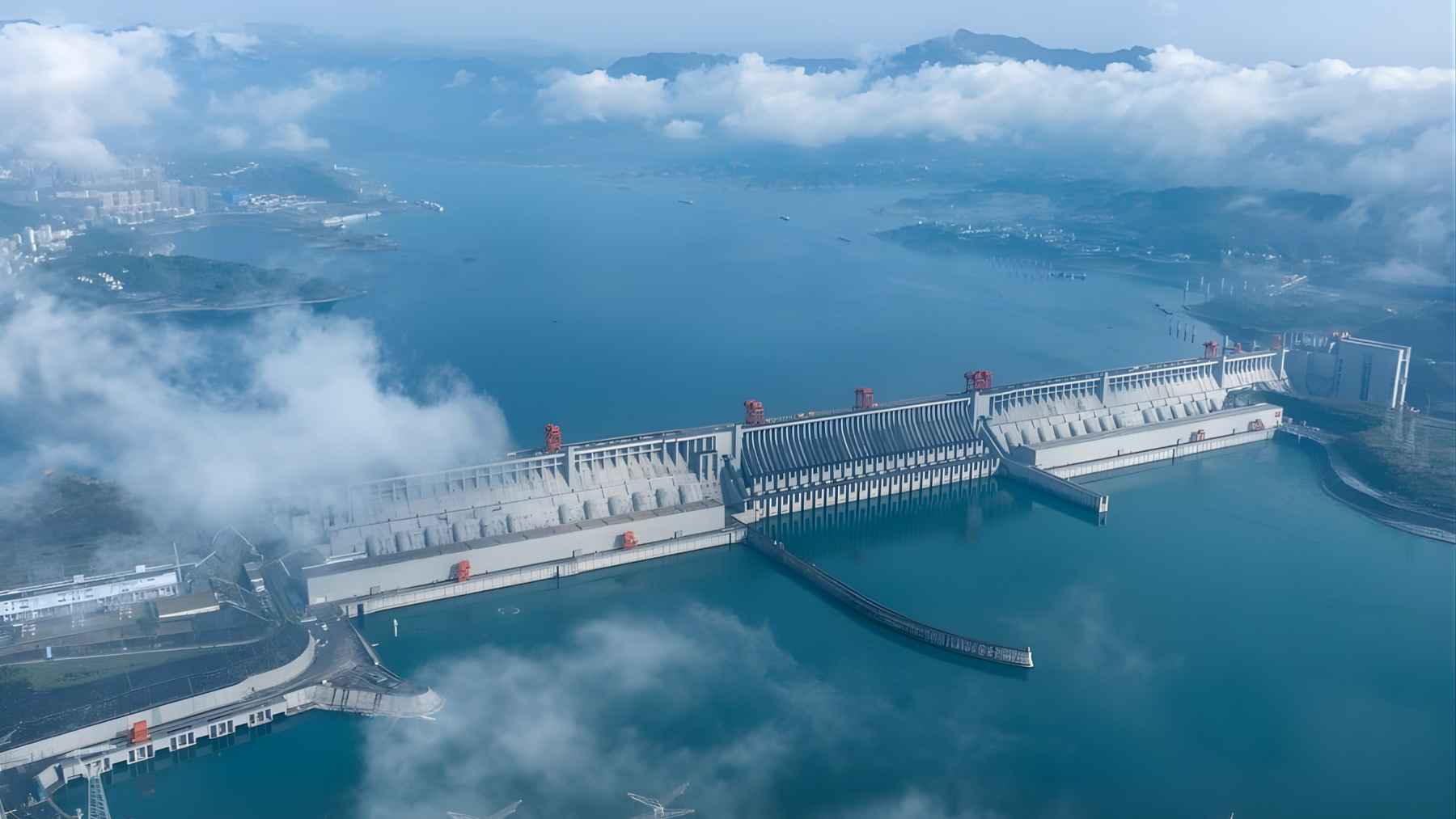Aerial view of China’s Three Gorges Dam surrounded by water and low clouds, illustrating the massive hydropower project.