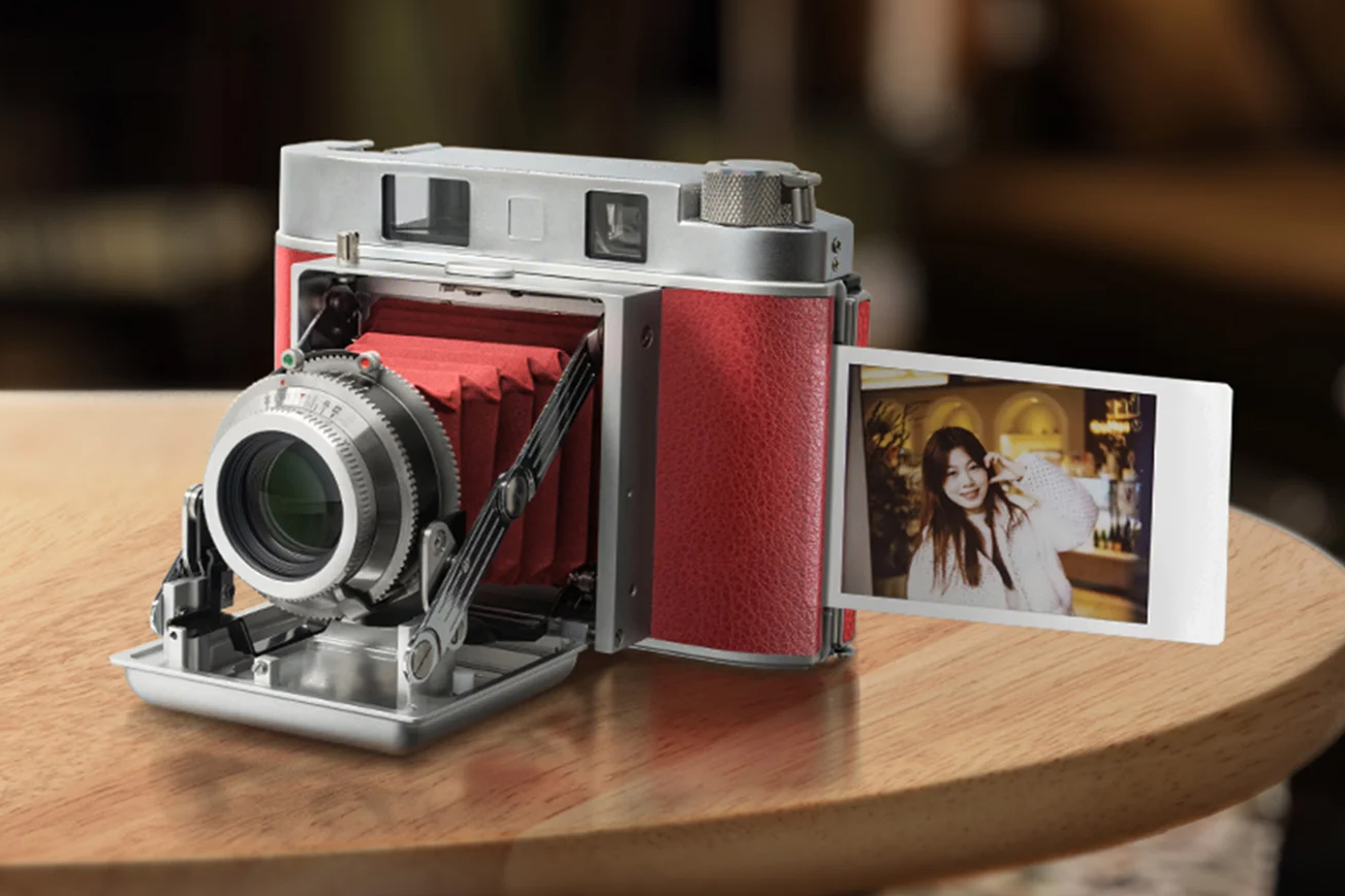 The TTArtisan 203T camera with an instant print sticking out of the side.