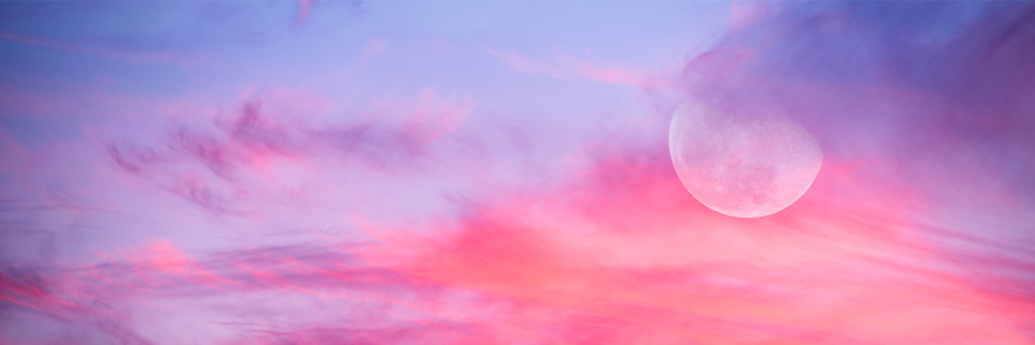 a moon in the sky surrounded by pink and purple whispy clouds