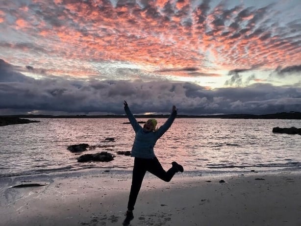 Silhouette of Deirdre Mullins jumping on a beach at sunset