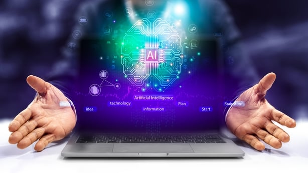 A man holding a laptop with a computer generated image of a brain and the AI symbol