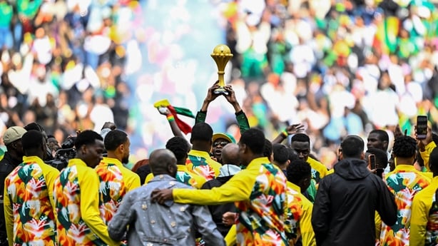 Senegalese musician Youssou N'Dour (C) holds The African Cup of Nations Trophy as Senegal's players gather around him ahead of the international friendly football match between Senegal and Peru at the Stade de France