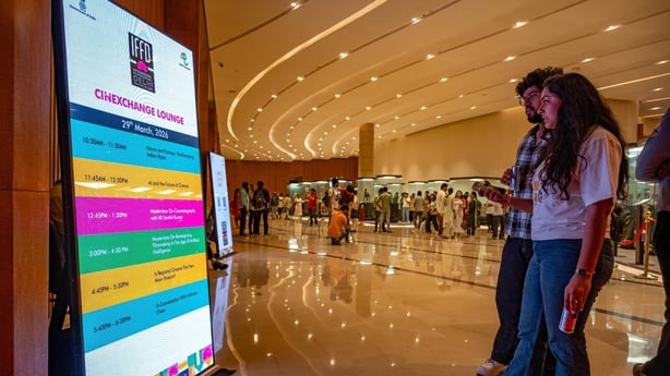 Visitors look at the information screen for the schedule of events during the International Film Festival Delhi (IFFD) 2026. (Photo by Pradeep Gaur/SOPA Images/LightRocket via Getty Images)