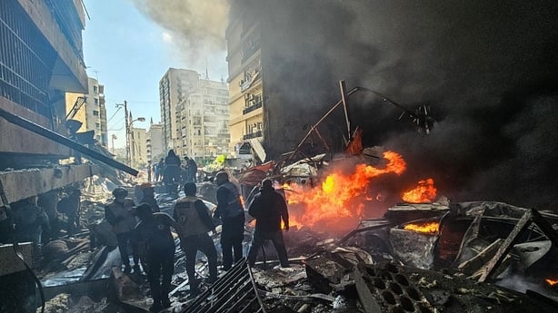 First responders stand amid rubble at the site of an Israeli airstrike in Beirut's Corniche al-Mazraa neighbourhood 