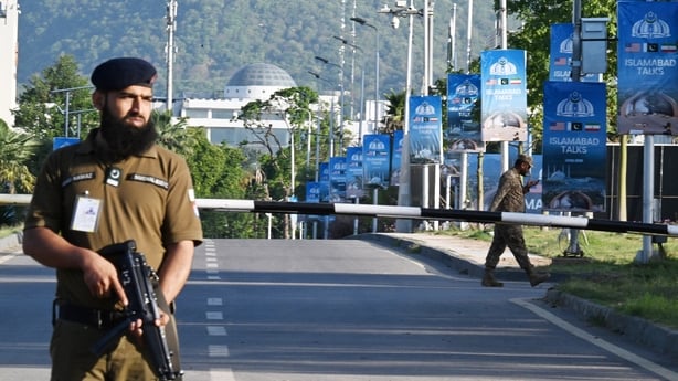 Police officers stand guard at a closed road leading to the Serena Hotel at the Red Zone area in Islamabad