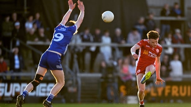 Aodhán Quinn of Tyrone kicks a score despite the efforts of Matthew Carolan of Monaghan during the Dalata Hotel Group Ulster U20 Football Championship final match between Monaghan and Tyrone at BOX-IT Athletic Grounds in Armagh.