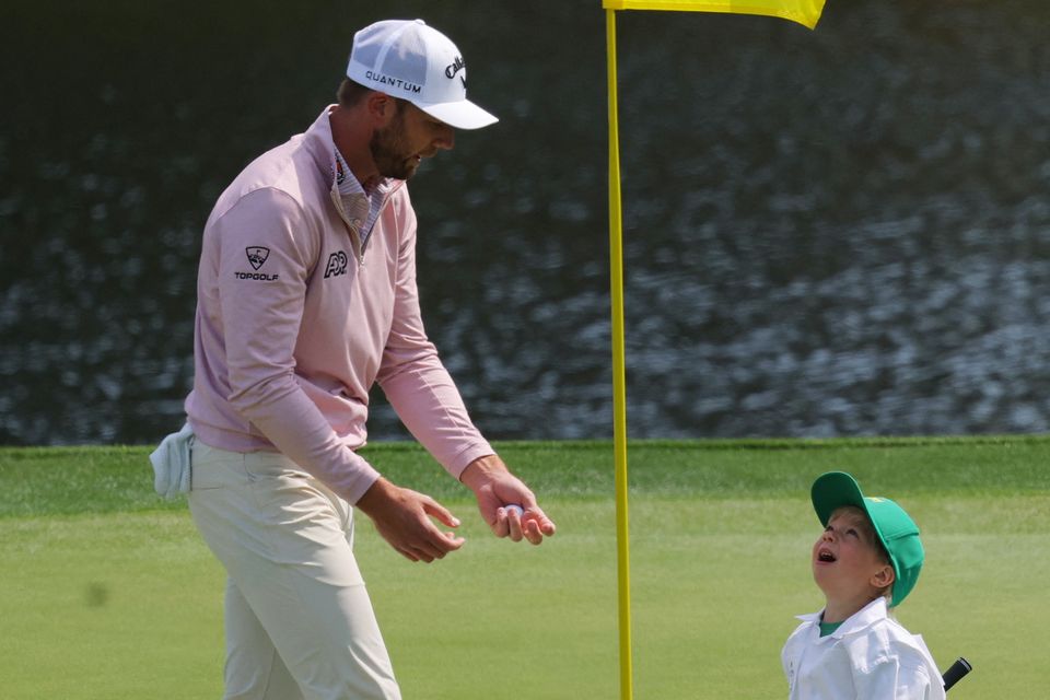 Golf - The Masters - Augusta National Golf Club, Augusta, Georgia, U.S. - April 8, 2026
Sam Burns of the U.S. with his son Bear Burns on the 1st hole during the par 3 contest REUTERS/Mike Segar