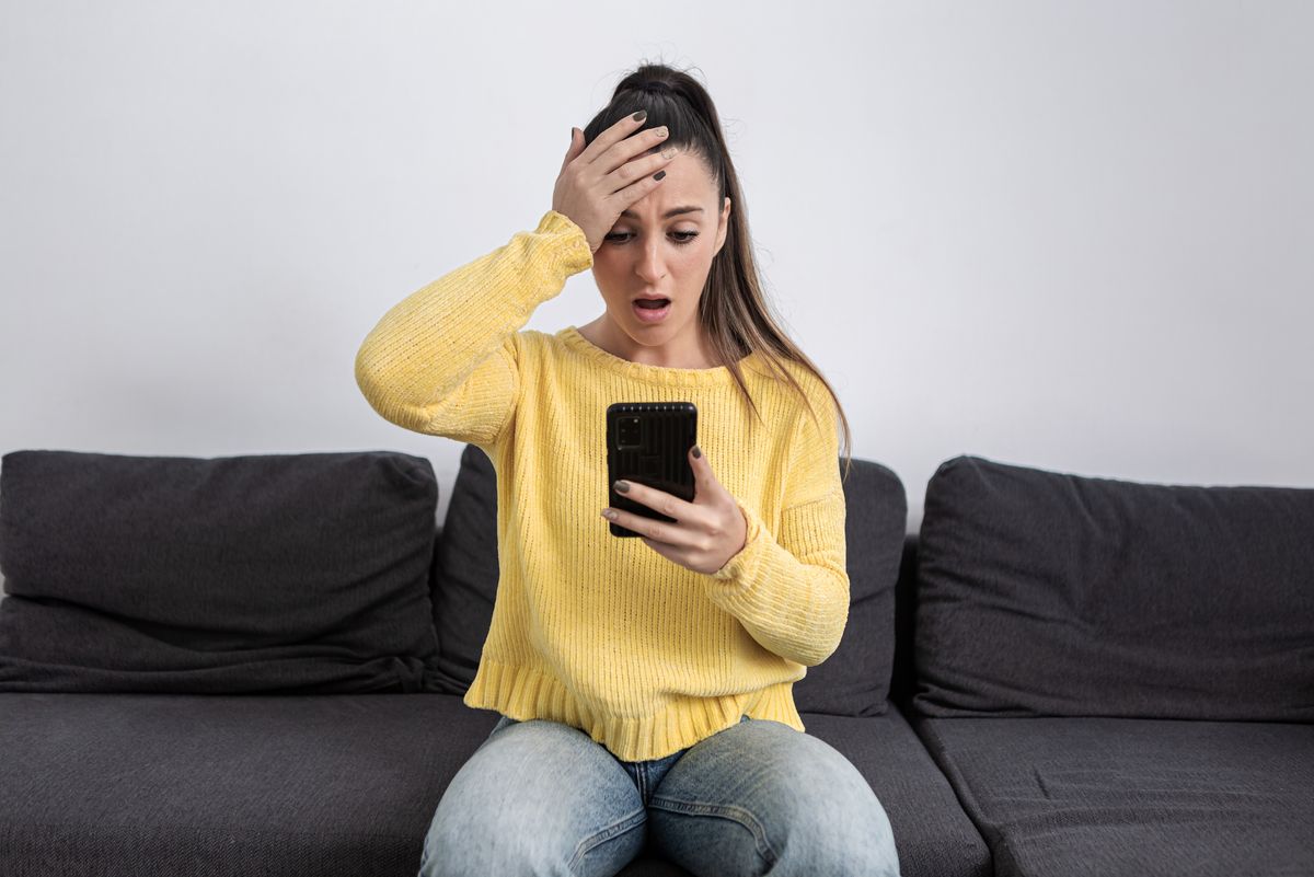 Young woman looking shocked at her phone