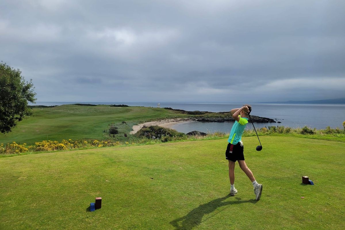 A young golfer tees off at Greencastle Golf Club in Co Donegal, overlooking Lough Foyle