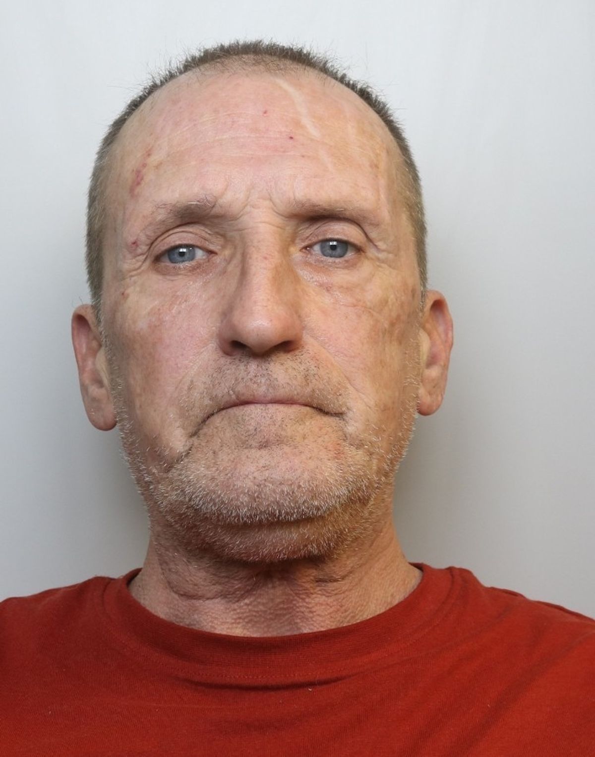 Mugshot of man in red t-shirt
