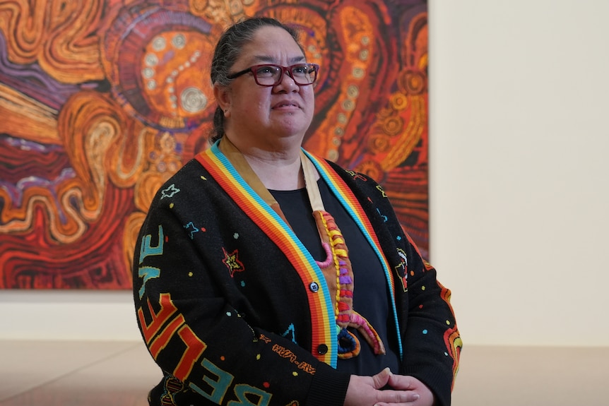 A woman stands in an art gallery.