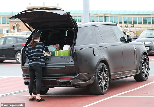 She was seen loading up the boot of her black Range Rover with multiple bags from Waitrose and various luxury brands