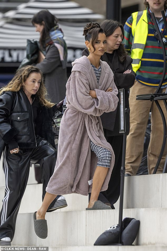 The Love Island star wrapped up in a pink dressing gown covering over a black and white gingham top and matching skinny three-quarter trousers