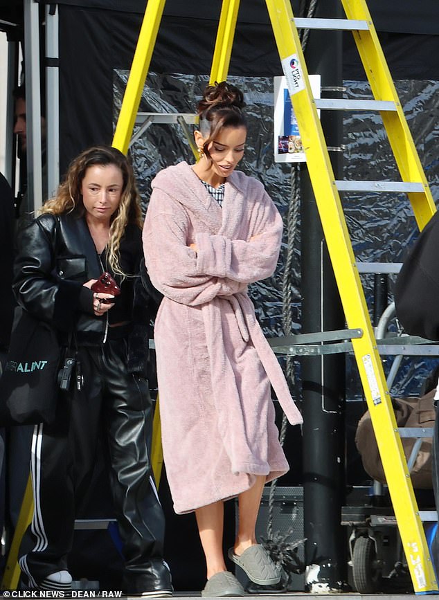 The Irish model kept comfortable in a pair of grey slippers as she arrived on set with her team