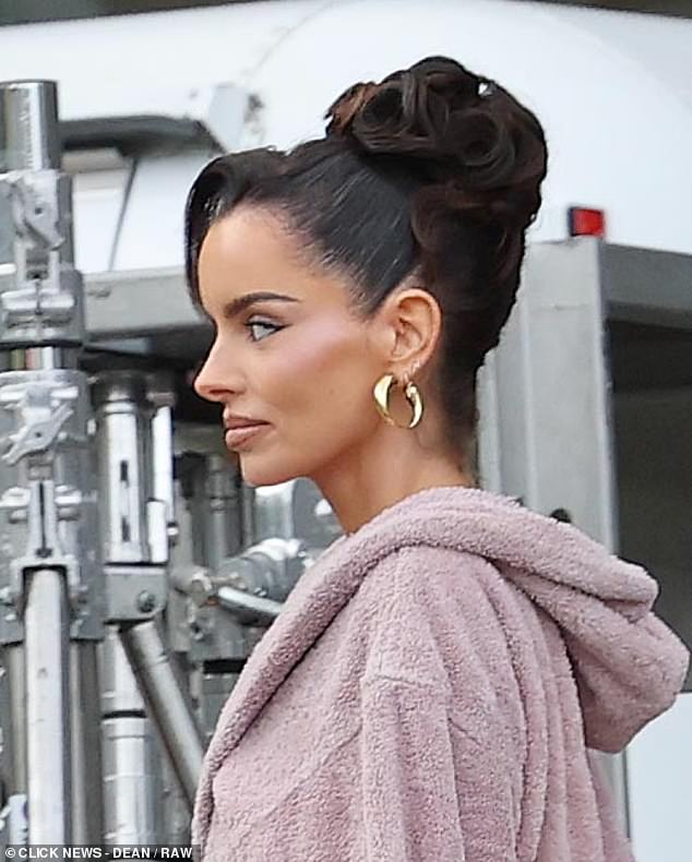 Maura wore a full face of snatched makeup, including contour and blushed cheeks, and styled her long brunette tresses in a sleek curled up do