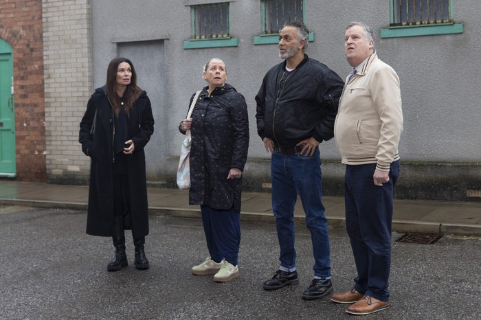 Carla, Bernie, Dev and Brian look upwards at Roy's Rolls flat in Coronation Street