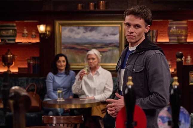 Manpreet Sharma sharing a drink with Caitlin Todd as Jacob Gallagher looks downcast