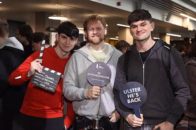 Arnold Schwarzenegger fans hold plaques ahead of a ceremony presenting him with an honorary doctorate at Ulster University in Belfast