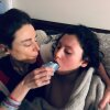 Alessandra Fabrello (left) holds a cup to the lips of her son Ysadore Maklakoff as he reclines and she hugs him.