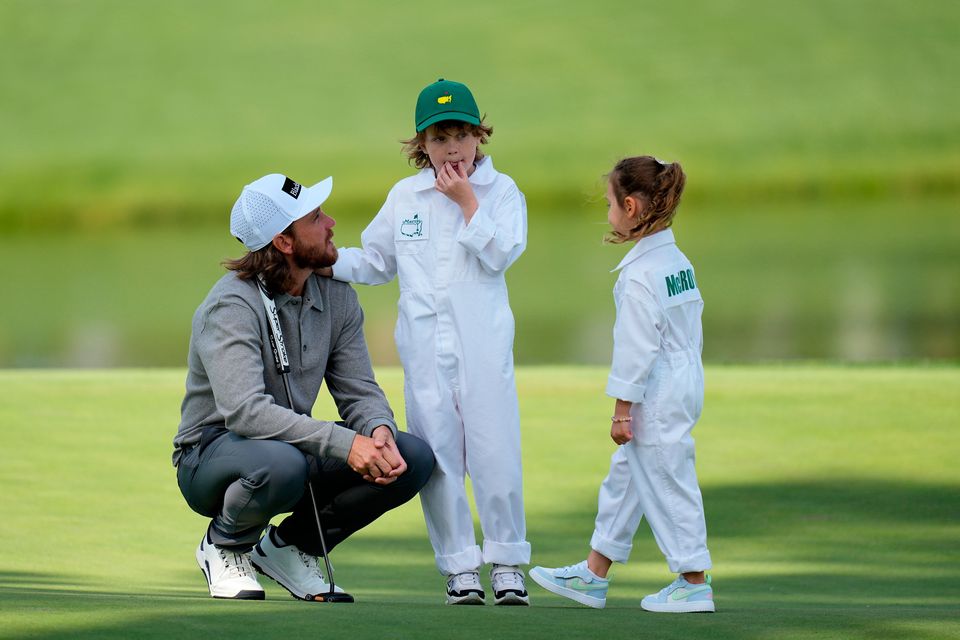 Tommy Fleetwood, left, talks with his son, Franklin, center, and Rory McIlroy's daughter, Poppy, during par-3 contest ahead of the Masters golf tournament at the Augusta National Golf Club, Wednesday, April 8, 2026, in Augusta, Ga. (AP Photo/Eric Gay)