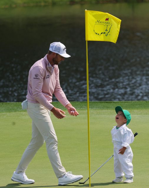 Golf - The Masters - Augusta National Golf Club, Augusta, Georgia, U.S. - April 8, 2026
Sam Burns of the U.S. with his son Bear Burns on the 1st hole during the par 3 contest REUTERS/Mike Segar