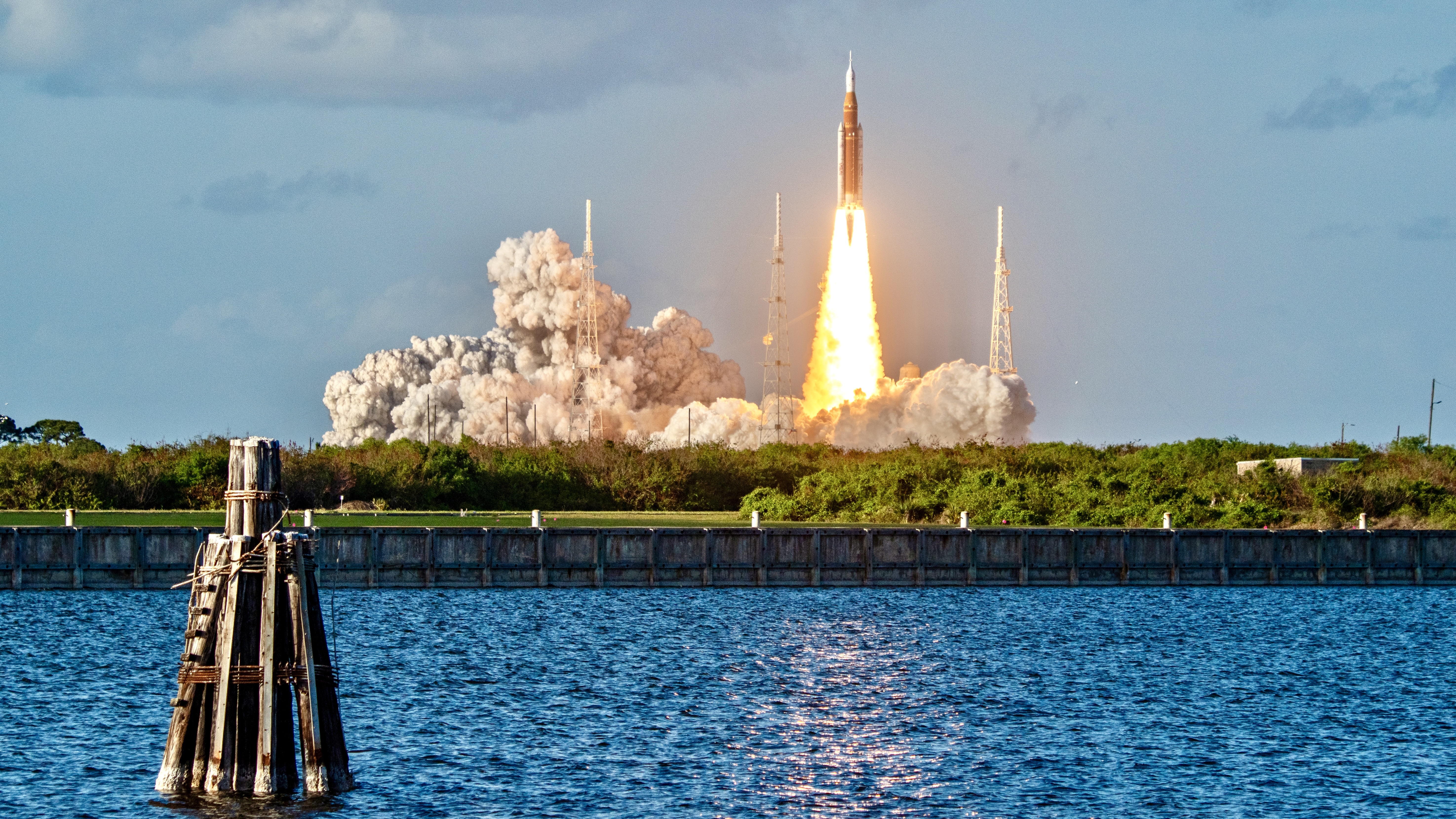 a rocket launches above a plume of fire