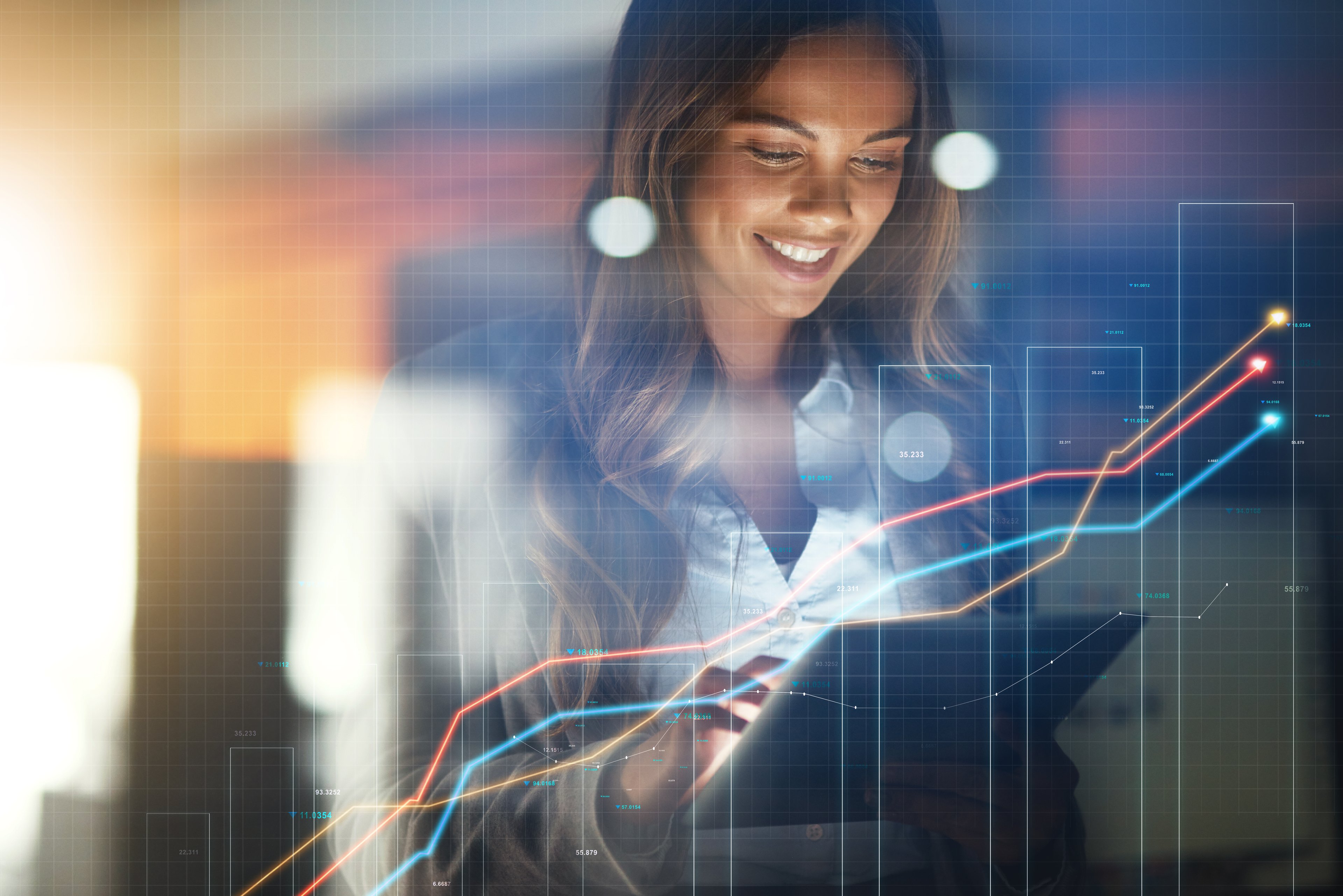 Person smiling and holding a tablet with charts superimposed in front of the picture.