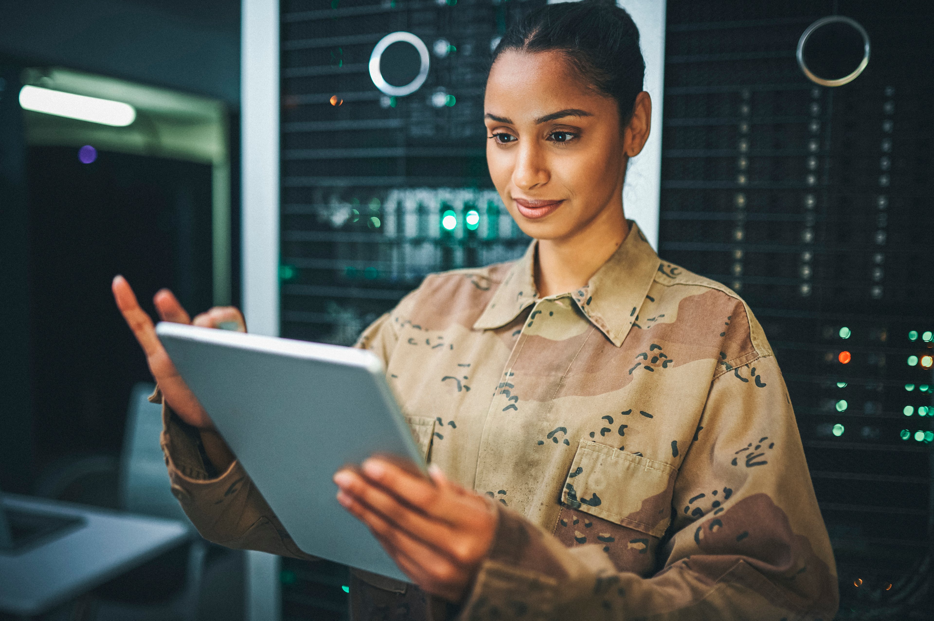 A soldier analyzes data inside a data center.