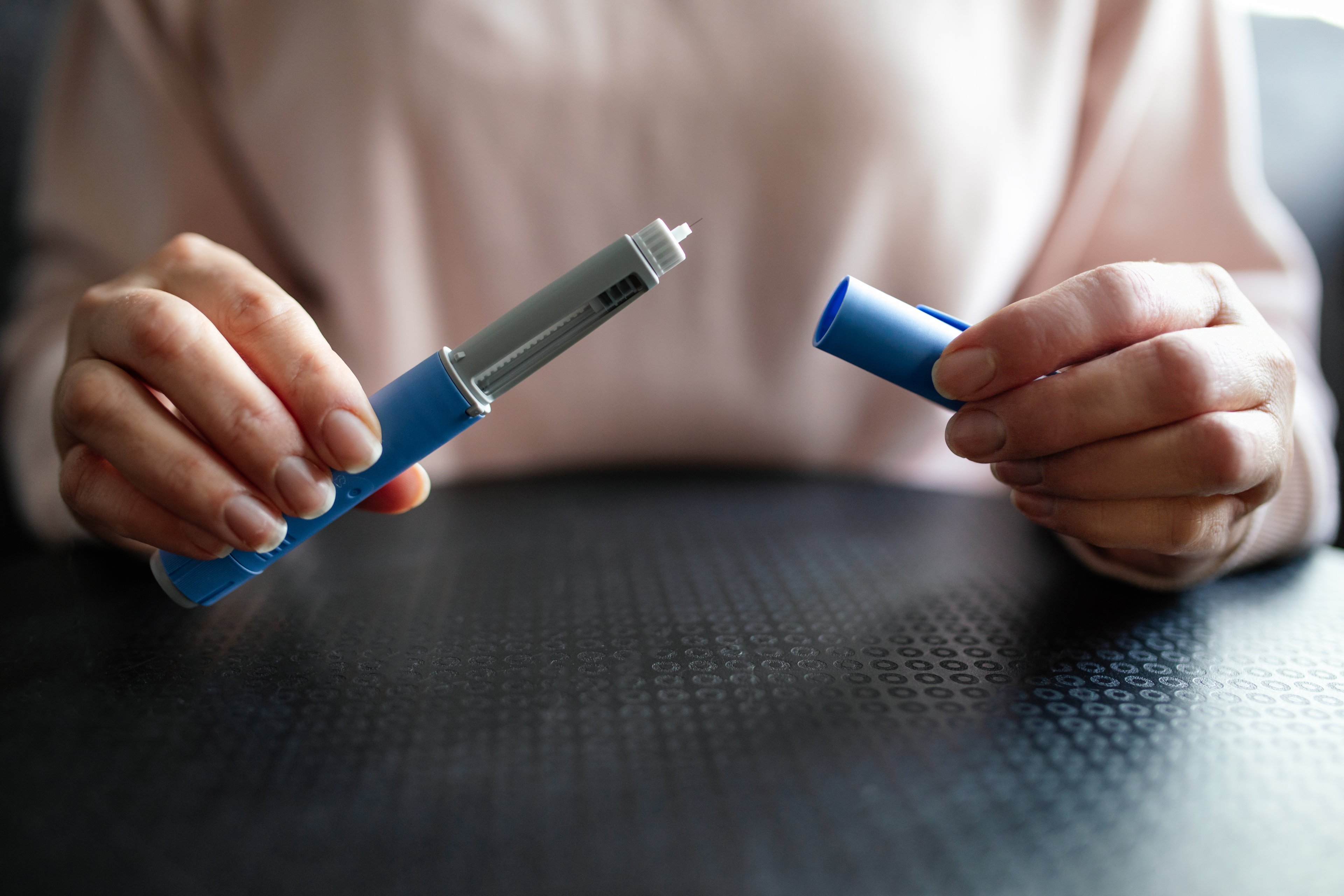 A person opens a GLP-1 shot