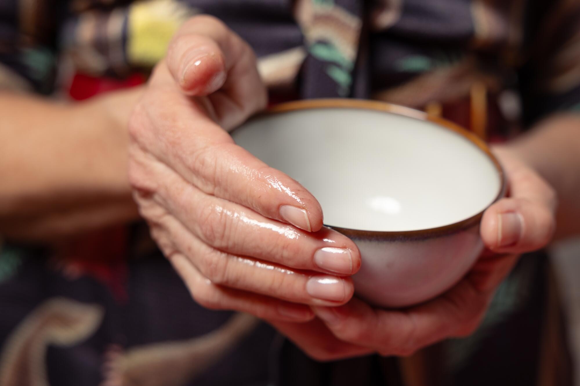 Leigh McDaniel holds a bowl of coconut and castor oil that she often uses with clients.