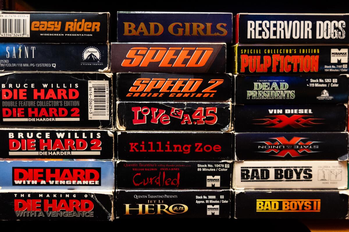 Videocassettes sit in stacks on a shelf.
