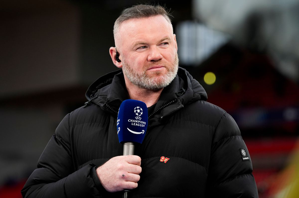 Wayne Rooney holds a microphone