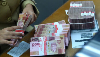 An employee counts rupiah bills on March 14 at a money changer in Jakarta.