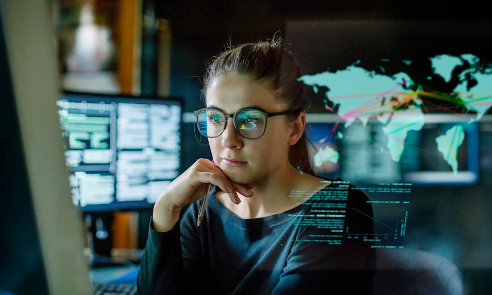 A Wall Street trader sitting at their desk looking at stocks on a computer screen.
