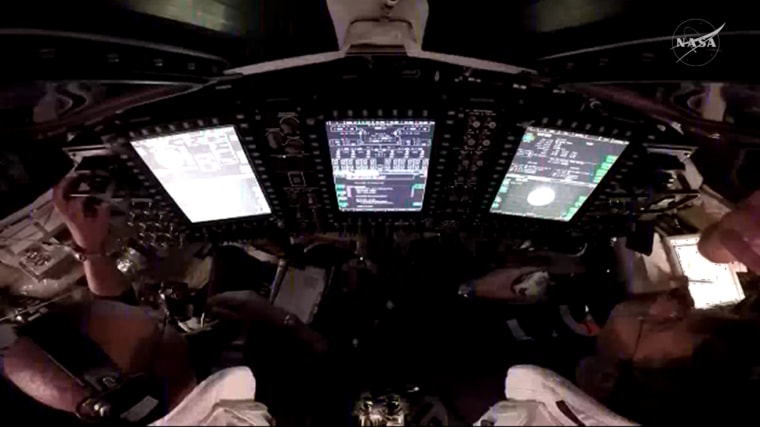 A view over the shoulders of NASA astronauts Victor Glover (left) and Reid Wiseman (right), pilot and commander