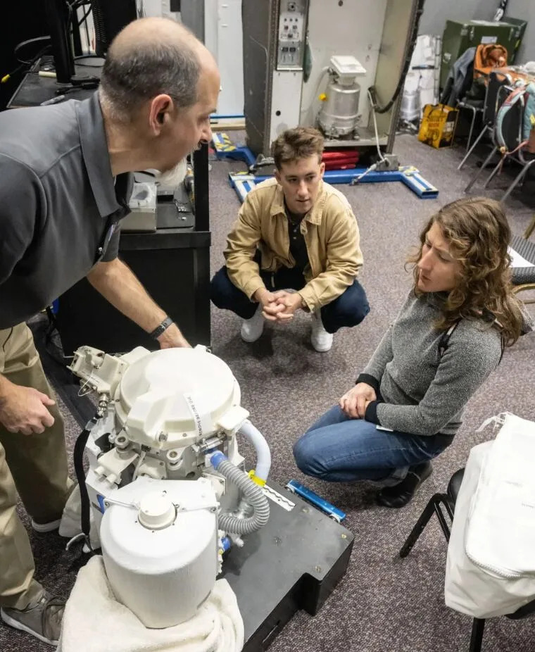 Astronaut and mission specialist Christina Koch looks at the Universal Waste Management System.