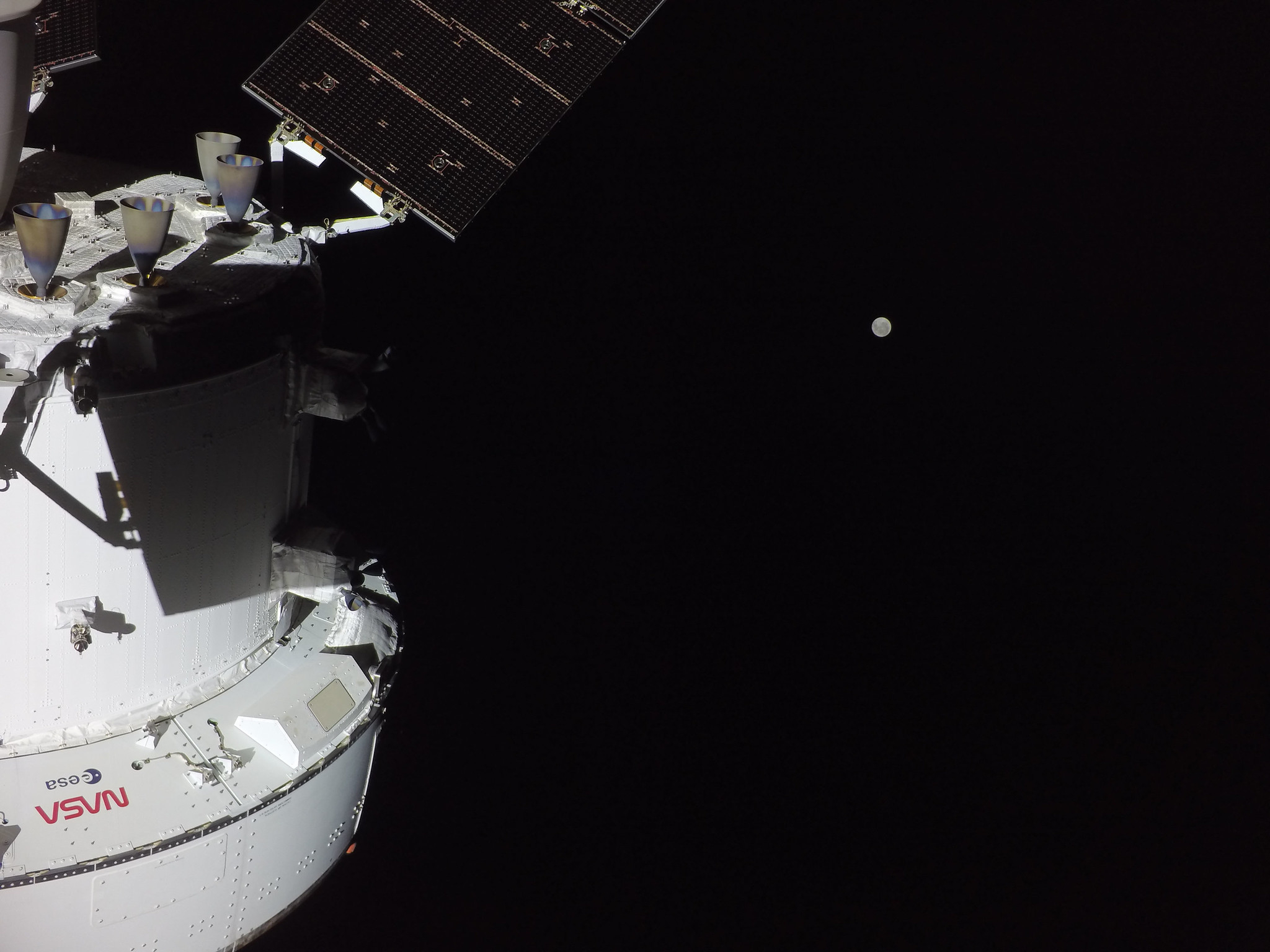 The Artemis II crew is en route to the Moon on the second flight day of the mission. This photo shows the Orion spacecraft with the Moon in the distance, as captured by a camera on the tip of one of its solar array wings.