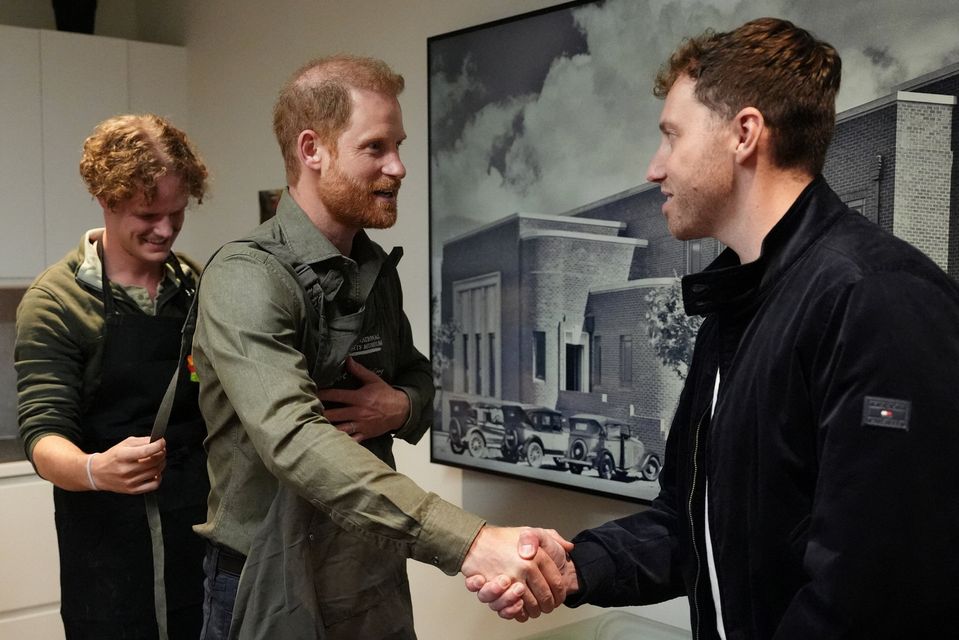 Britain's Prince Harry, the Duke of Sussex shakes hands with a veteran as he prepares to take part in a model-making activity with veterans and their families at the Australian National Veterans Arts Museum (ANVAM) in Southbank, Melbourne, Australia, April 14, 2026. Jonathan Brady/Pool via REUTERS