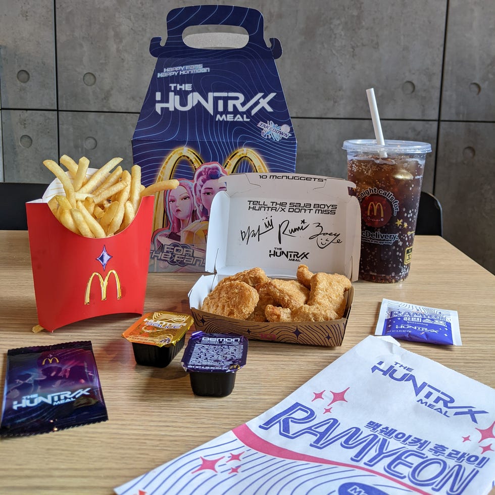 Fast food meal from McDonald's featuring fries, chicken nuggets, sauces, and a drink.