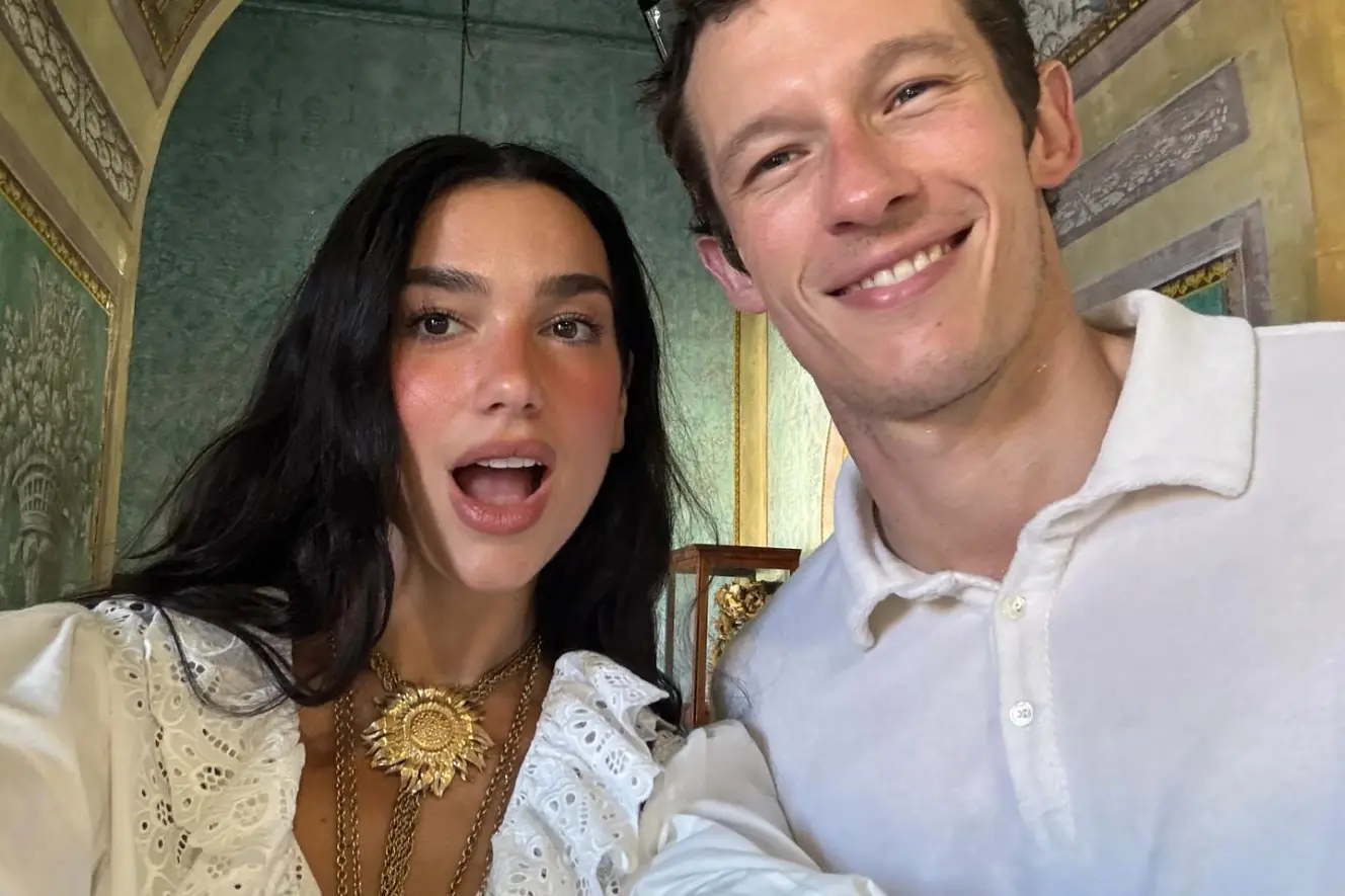Dua Lipa and Romain Gavras smiling at the camera.
