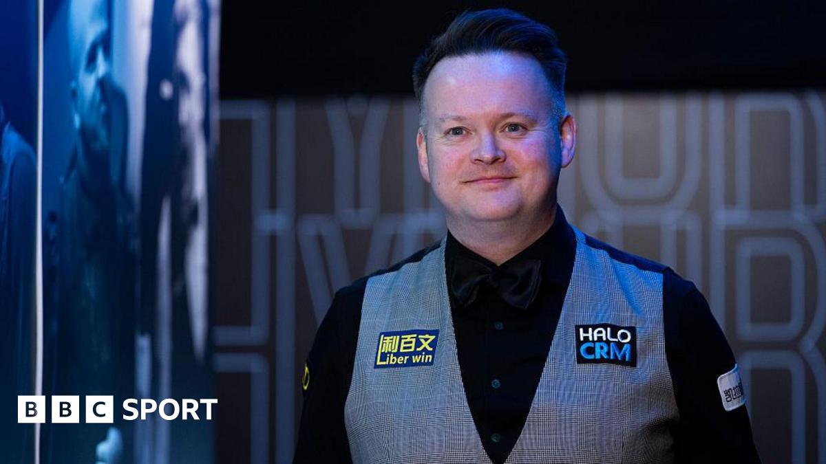 A smiling Shaun Murphy in black shirt and bow tie, and grey waistcoat