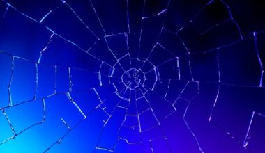 An extreme close-up of a shattered, cracked glass surface in deep shades of blue and purple, conceptually representing the fragile and complex relationship between the characters on the medical drama series