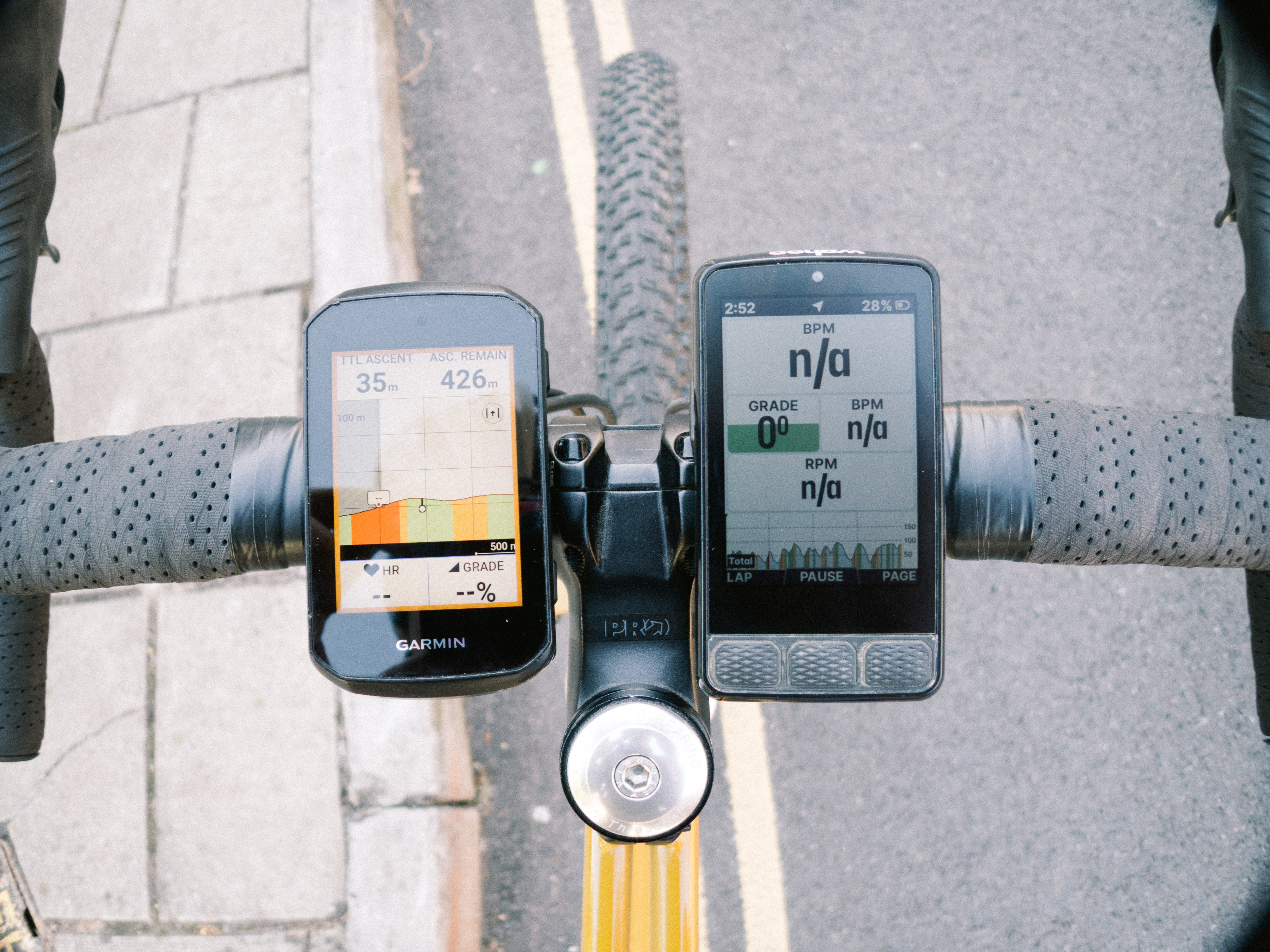 Two bike computers side by side on a gravel bike handlebar