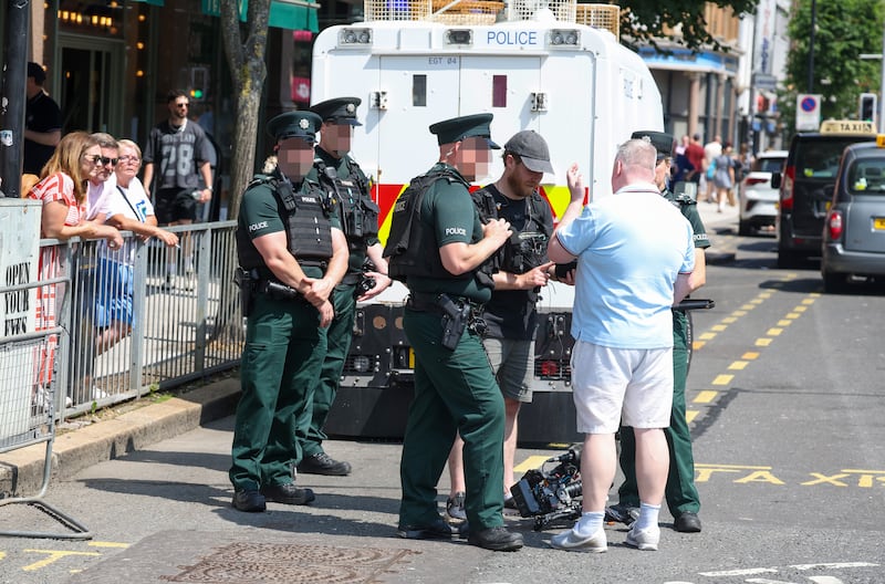 Stephen Nolan in Belfast City Centre speaking with PSNI officers while making a documentry