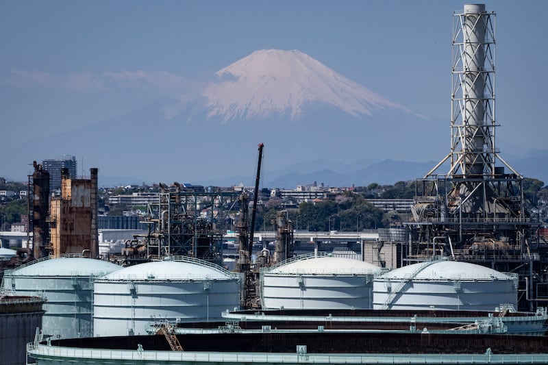 Storage tanks are seen at an oil refinery in Yokohama, Japan, as Mount Fuji looms in the background. Photograph: Yuichi Yamazaki/AFP via Getty Images